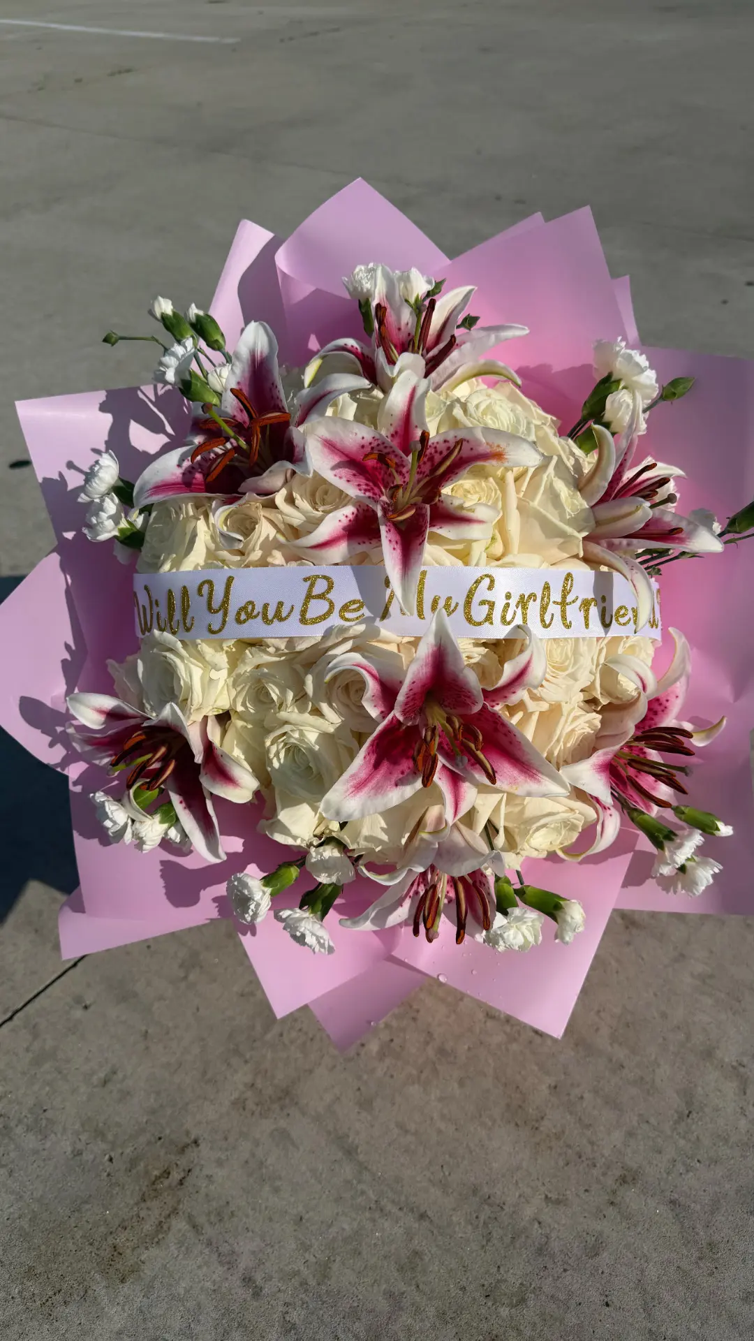 White rose and stargazer lily bouquet with a 'Will You Be My Girlfriend' ribbon