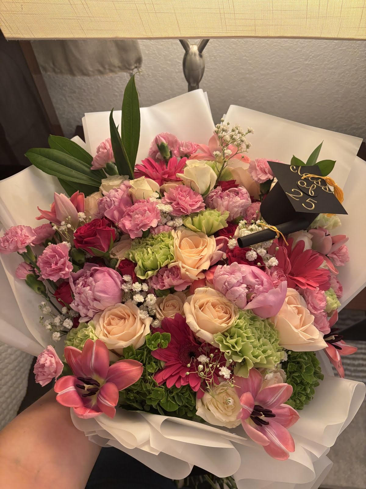 Graduation bouquet with pink and cream roses and a class of 2025 cap